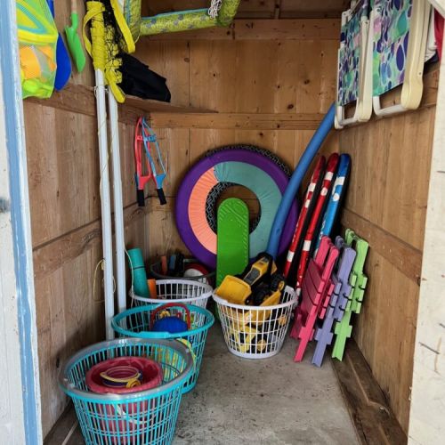 Beach toys for the kids and lounge chairs stored in the shed near the water.