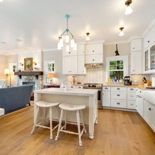 The fully equipped kitchen includes classic white cabinetry, butcher block counters, a drip coffee maker, and dishwasher—perfect for preparing meals together.