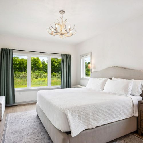 The primary suite features a king bed with a Smart TV and a luxurious ensuite bath complete with a walk-in shower and soaking tub-your own private retreat after a day of exploring.