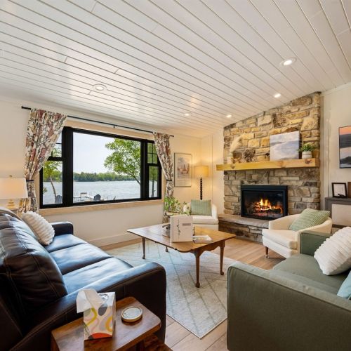 The open concept main living space has gorgeous lake views, a gas fireplace, and easy access to the lakeside of the home.