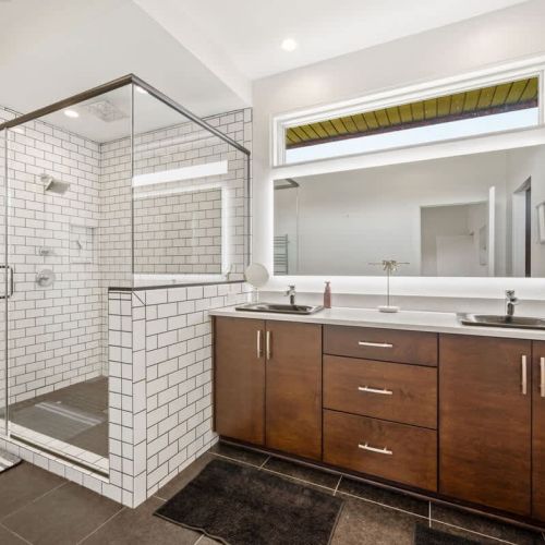 The main-floor primary suite offers a comfortable king bed and a serene, spa-inspired ensuite complete with a large walk-in shower.