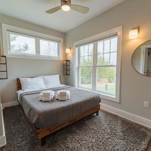 This charming bedroom, featuring a plush queen bed, is your perfect sanctuary. Enjoy the serene ambiance with stylish decor and soft lighting, creating a warm and inviting atmosphere.