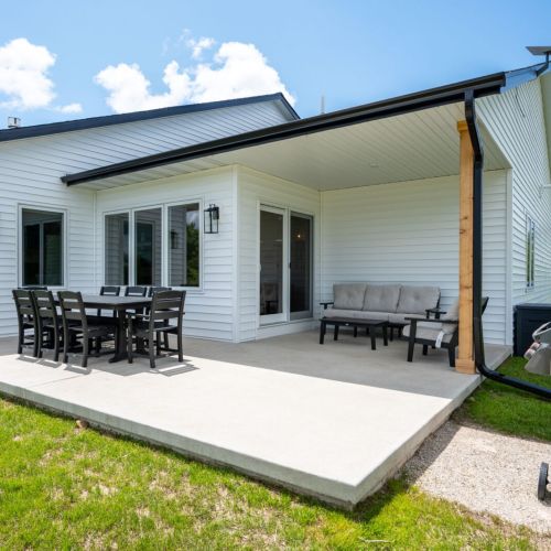 An outdoor dining set, BBQ grill, and comfortable seating area create the perfect space to unwind and enjoy fresh Door County air.
