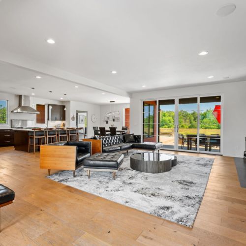 A spacious, modern open-concept living area brings everyone together, while a glowing fireplace and Smart TV create the perfect backdrop for relaxation and entertainment.