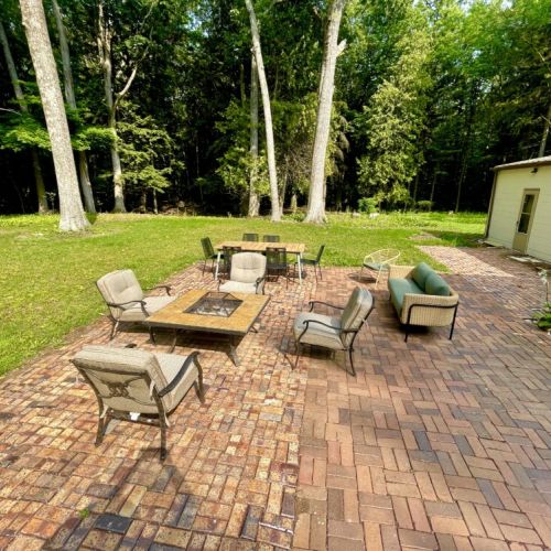 Fully furnished back patio-ideal for campfires under the stars, alfresco dining and enjoying the serenity of the quiet wooded lot. It's not uncommon to have deer peacefully exploring right outside your door!