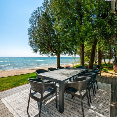 Step outside from the main living room onto this inviting deck, where outdoor dining meets the tranquil beauty of Lake Michigan.