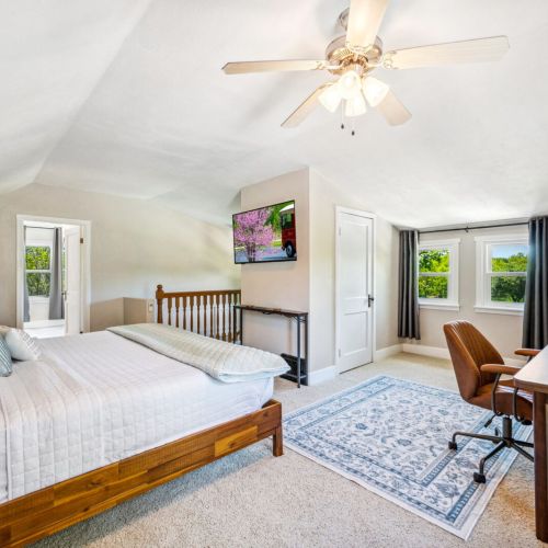 Retreat to the spacious upper-level main bedroom suite, featuring a luxurious king-sized bed and a dedicated workspace. This private oasis offers comfort and tranquility, perfect for relaxation and productivity.