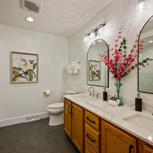 Primary bathroom with dual sinks and a luxury walk-in shower with a rain shower head.