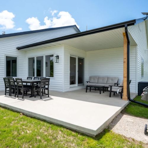 An outdoor dining set, BBQ grill, and comfortable seating area create the perfect space to unwind and enjoy fresh Door County air.