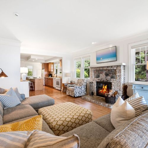 Relax in comfort on the spacious sofa while enjoying the warmth of a cozy stone fireplace.