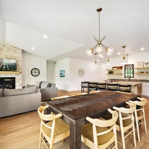 The fully equipped kitchen offers high-end appliances, a large center island, and plenty of room to cook and share stories while dining together at the table for eight.
