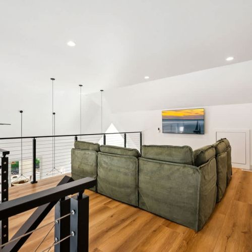 Overlooking the first floor, an additional living area provides a comfortable place of connection with large Smart TV-perfect for streaming your favorite TV shows and movies.