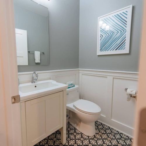 Convenient Half Bath: This stylish half bathroom is conveniently located off the main living area, ensuring easy access for guests. Featuring a modern design with a single vanity, ample storage, and a sleek toilet, this bathroom combines functionalit