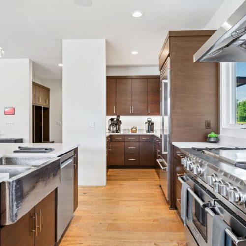 A well-appointed chef’s kitchen awaits, featuring a coffee bar, pantry, and adjacent mudroom with laundry.