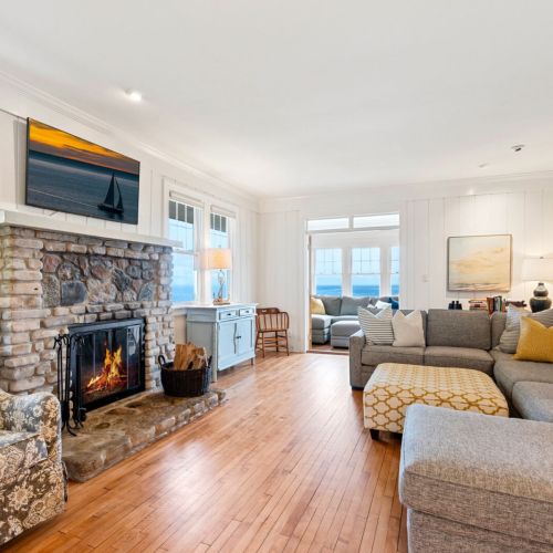 Relax in comfort on the spacious sofa while enjoying the warmth of a cozy stone fireplace.