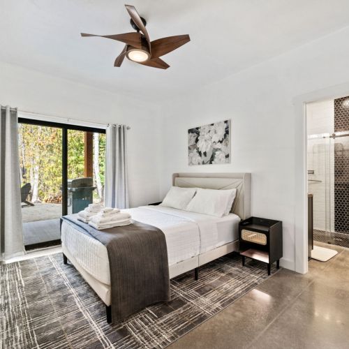 The master bedroom features a comfortable queen bed and en-suite full bathroom with double vanities and curb-less walk-in shower. Along with direct outdoor patio access. Queen bedroom #3