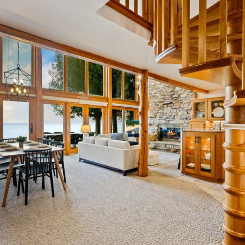 Open-concept great room with a stone fireplace overlooking Lake Michigan.
