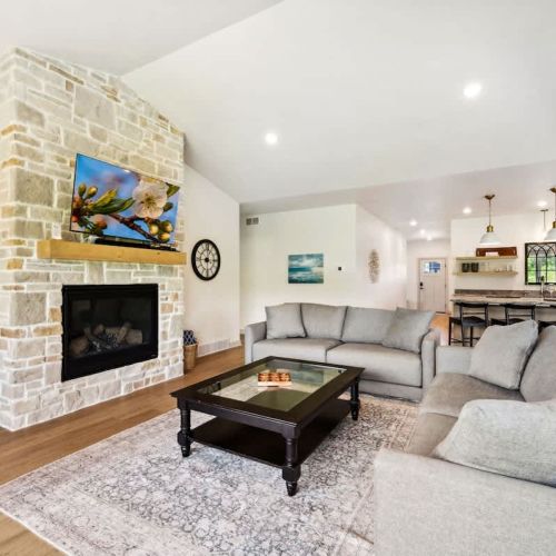 The cozy living room is centered around plush seating and a Smart TV, perfect for movie nights, morning cartoons, or rainy-day board games.