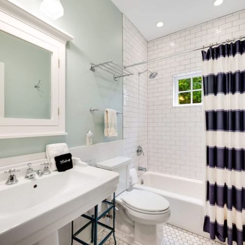 The first-floor bathroom is conveniently located off the main living area, situated between the Queen bedroom and the bunk room.