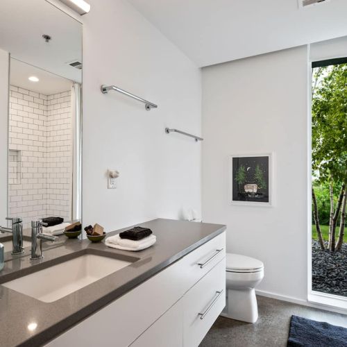 Crisp, clean, and well-lit. A spa-like bathroom with thoughtful details and a touch of modern simplicity.