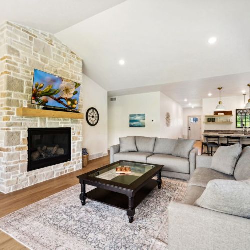 The cozy living room is centered around plush seating and a Smart TV, perfect for movie nights, morning cartoons, or rainy-day board games.