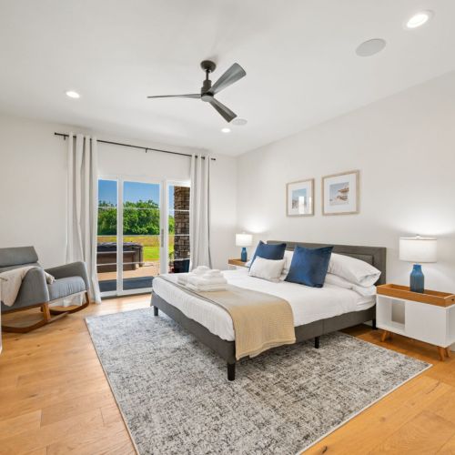 The main-floor primary suite offers a comfortable king bed and a serene, spa-inspired ensuite complete with a large walk-in shower.