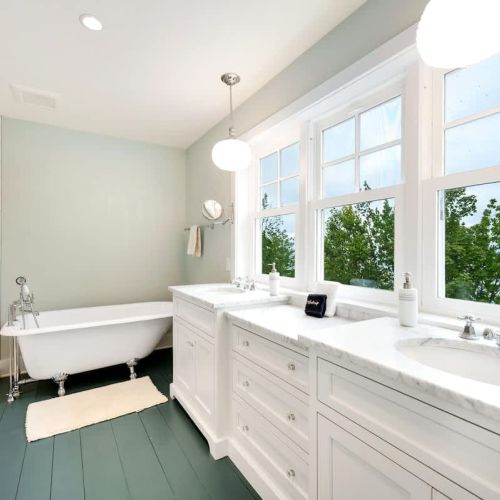 The upstairs master suite a luxury ensuite bath with dual vanities, a clawfoot tub, and a spacious walk-in shower.