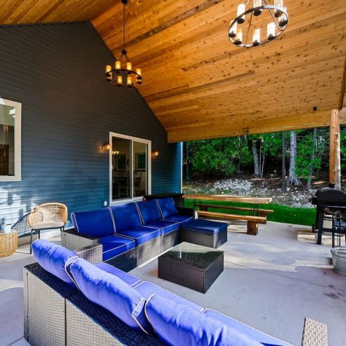 Relish the expansive outdoor living space, featuring a magnificent outdoor fireplace. Share laughter and stories under the starry night sky, enveloped by the tranquil forest setting.
