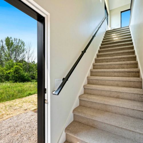 To enter the loft, you will use the side door of the garage and walk up the stairs.