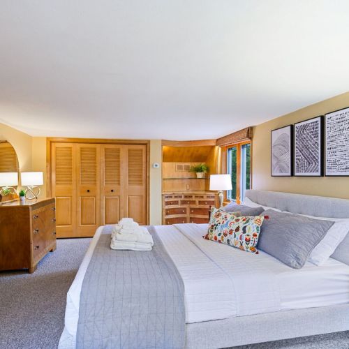 Revel in the spacious luxury of the upper-level King Suite , with beautiful built-in cabinetry and a comfortable seating area. A harmonious blend of comfort and style, making this bedroom a perfect private haven after a day of lakeside adventure.