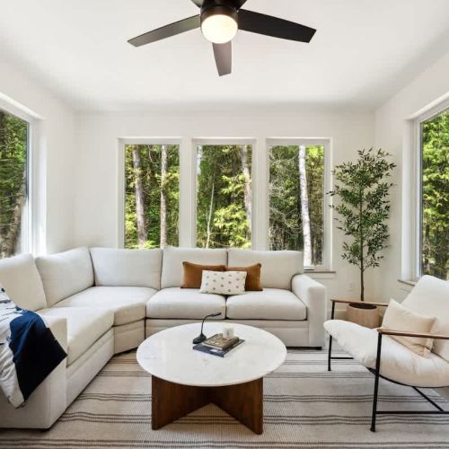 Surrounded by floor-to-ceiling windows, the four-season sunroom is the heart of the home. Enjoy the forest from the comfort of your plush sectional.