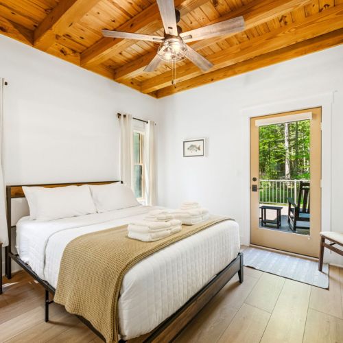 Just off the main living area, the private primary suite offers a comfortable queen bed, TV, cozy fireplace, and an ensuite bathroom complete with a soaking tub and spacious walk-in shower.