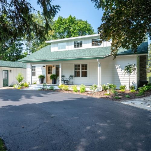 The entrance to Chicory Hill has a covered porch, a circular driveway, and natural stone walkways.