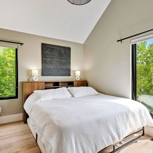 Bedroom #1 located in the Main House. Large windows offer stunning views of the wooded property.