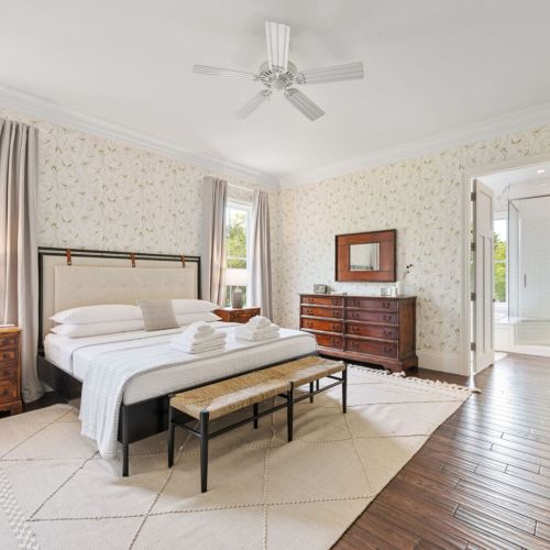 The master suite offers a comfortable king bed, a dedicated workspace upstairs, and an ensuite bathroom with a large soaking tub and a walk-in shower. Beautifully decorated, this space is designed to provide a serene escape.