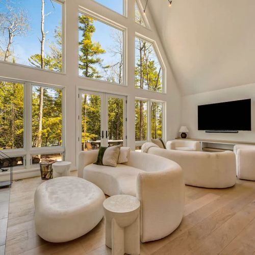 Floor-to-ceiling windows flood the room with natural light, showcasing the stunning natural views.