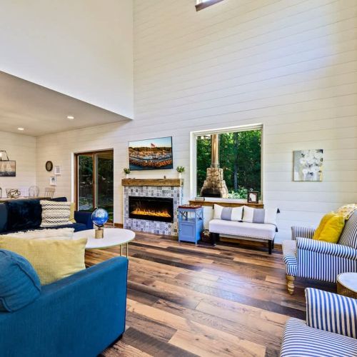 The main living area invites you to relish cozy comfort by the fireplace, with plenty of natural light and room to relax and entertain. Open concept floor plan allows effortless flow from living area to dining and kitchen.