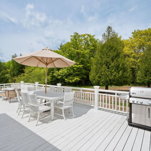 Step outside to discover the expansive outdoor space, designed for relaxation and enjoyment. The large deck is perfect for lounging or dining, offering panoramic views of the surrounding natural beauty