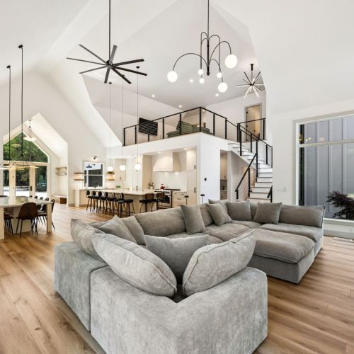 The open-concept living and dining areas boast soaring ceilings, large windows, and clean Scandinavian lines, creating a warm, light-filled space ideal for gathering