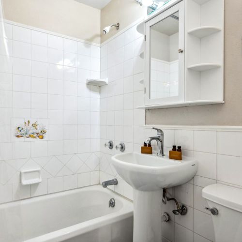 The main level bathroom features a clean, modern design with a full bathtub and shower combination. This bright and functional space is equipped with all the essentials for your stay.