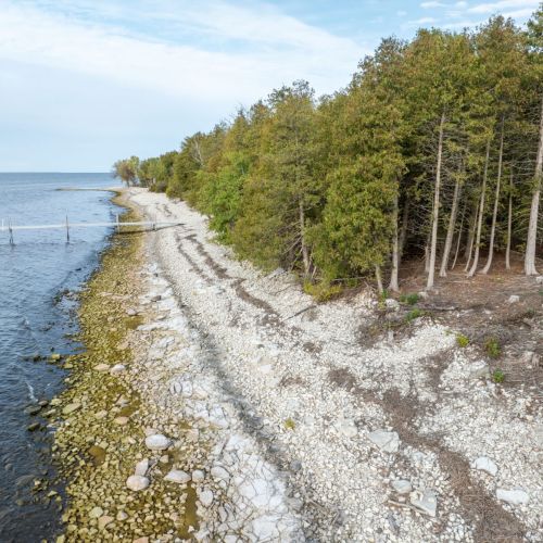 One hundred feet of Green Bay shoreline, accessible for most of the year to those comfortable navigating the natural, uneven terrain. The owner is planning future improvements to enhance accessibility.