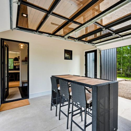 Garage/breezeway opens up to reveal a connective space to foster community and gathering, merging indoor and outdoor spaces.