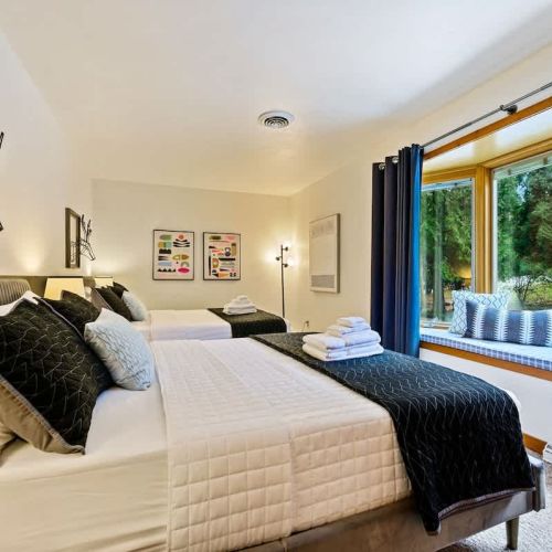 First floor bedroom with two queen beds. The linens are meticulously maintained, with care taken at our professional off-site laundry facility to ensure they meet the highest standards of cleanliness.