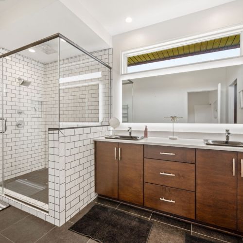 The main-floor primary suite offers a comfortable king bed and a serene, spa-inspired ensuite complete with a large walk-in shower.