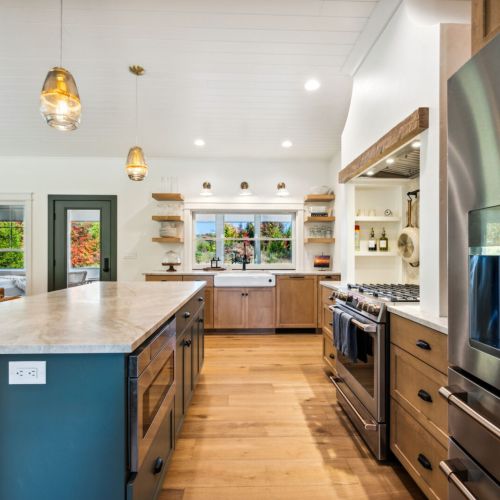 Step into the the gourmet kitchen, which is a chef’s dream, complete with high-end appliances and a fold-up window that opens into the large screened-in porch