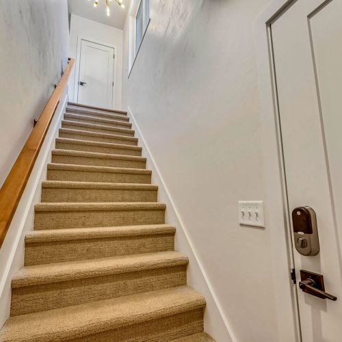 At the top of the stairs, you'll discover a private retreat featuring a fully equipped kitchen, a cozy family room, a spacious bedroom, and a full bathroom.