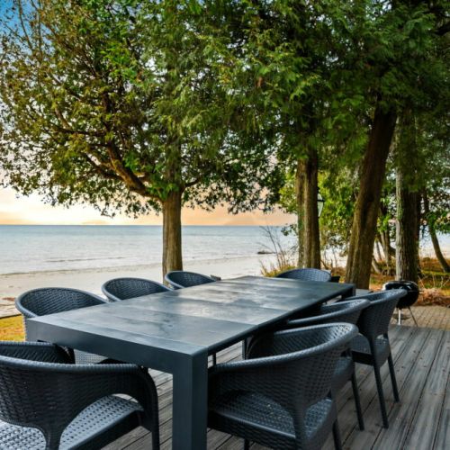 Step outside from the main living room onto this inviting deck, where outdoor dining meets the tranquil beauty of Lake Michigan.