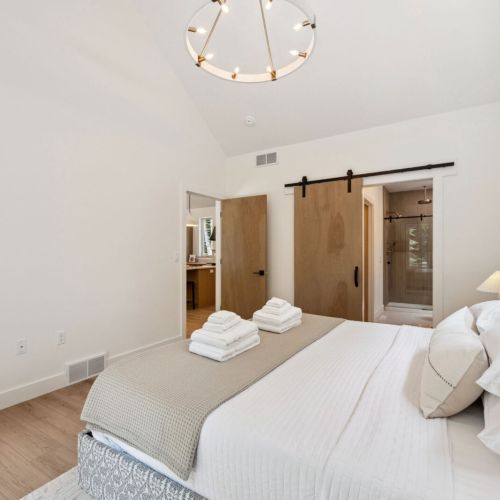 Wake up to treetop views in the luxurious primary suite featuring a king bed, spa-like en-suite, and organic textures that reflect the surrounding woods.