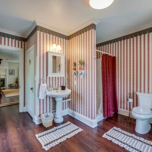 Take a peek at the Magnolia Suite's bathroom, equipped with a modern shower, an elegant vanity, and a comfortable chair-height toilet, ensuring both style and practicality in your daily routines.