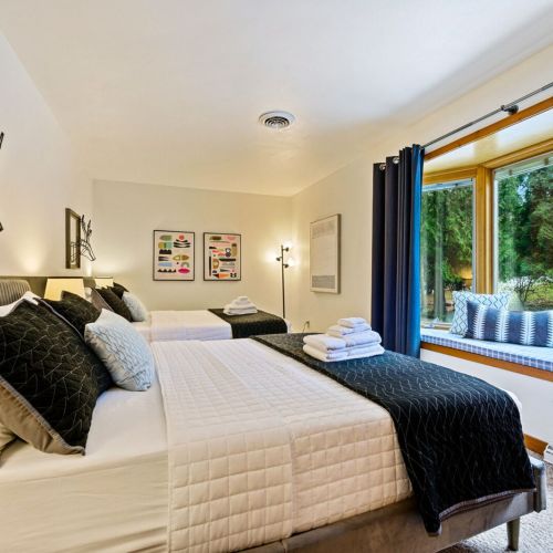 First floor bedroom with two queen beds. The linens are meticulously maintained, with care taken at our professional off-site laundry facility to ensure they meet the highest standards of cleanliness.